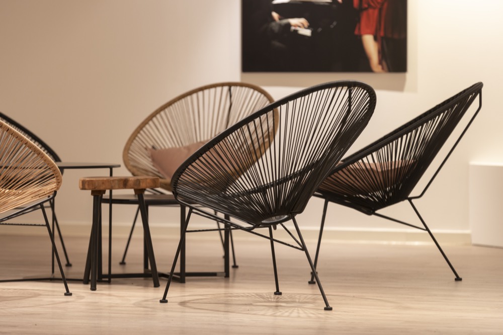 Lounge met zwarte draadstoelen en een lage tafel
