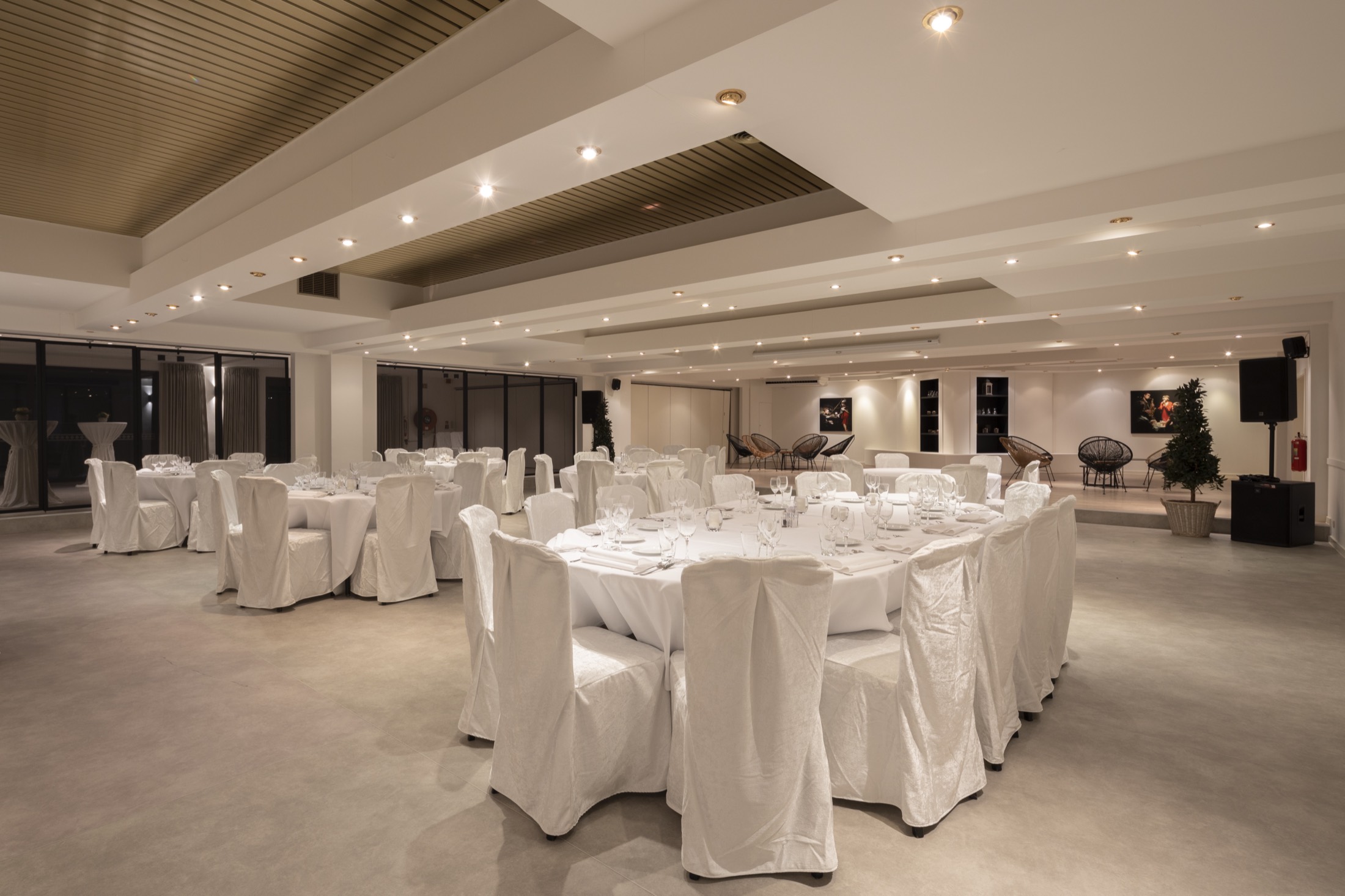 De grote zaal van De Lemenhoek, gedekt met witte tafels en stoelen onder een houten plafond